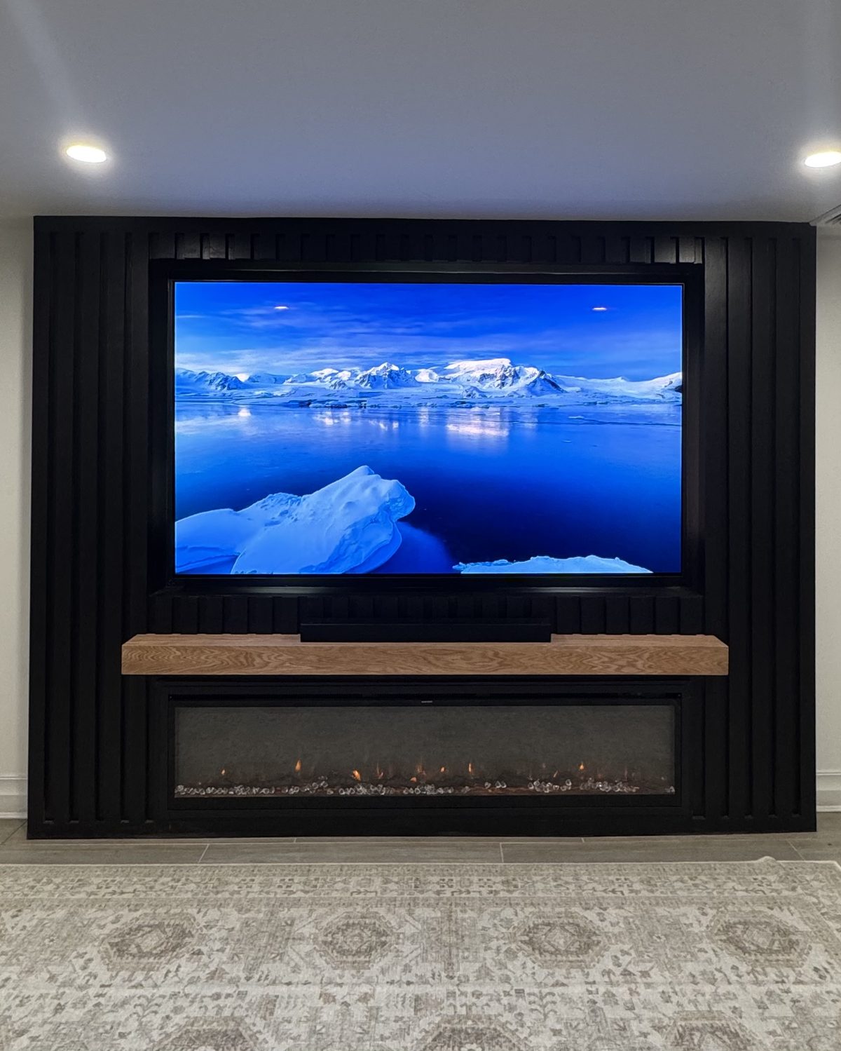 The Cinema Black: black slat buildout with recessed TV and solid wood mantel, by SEIN ME