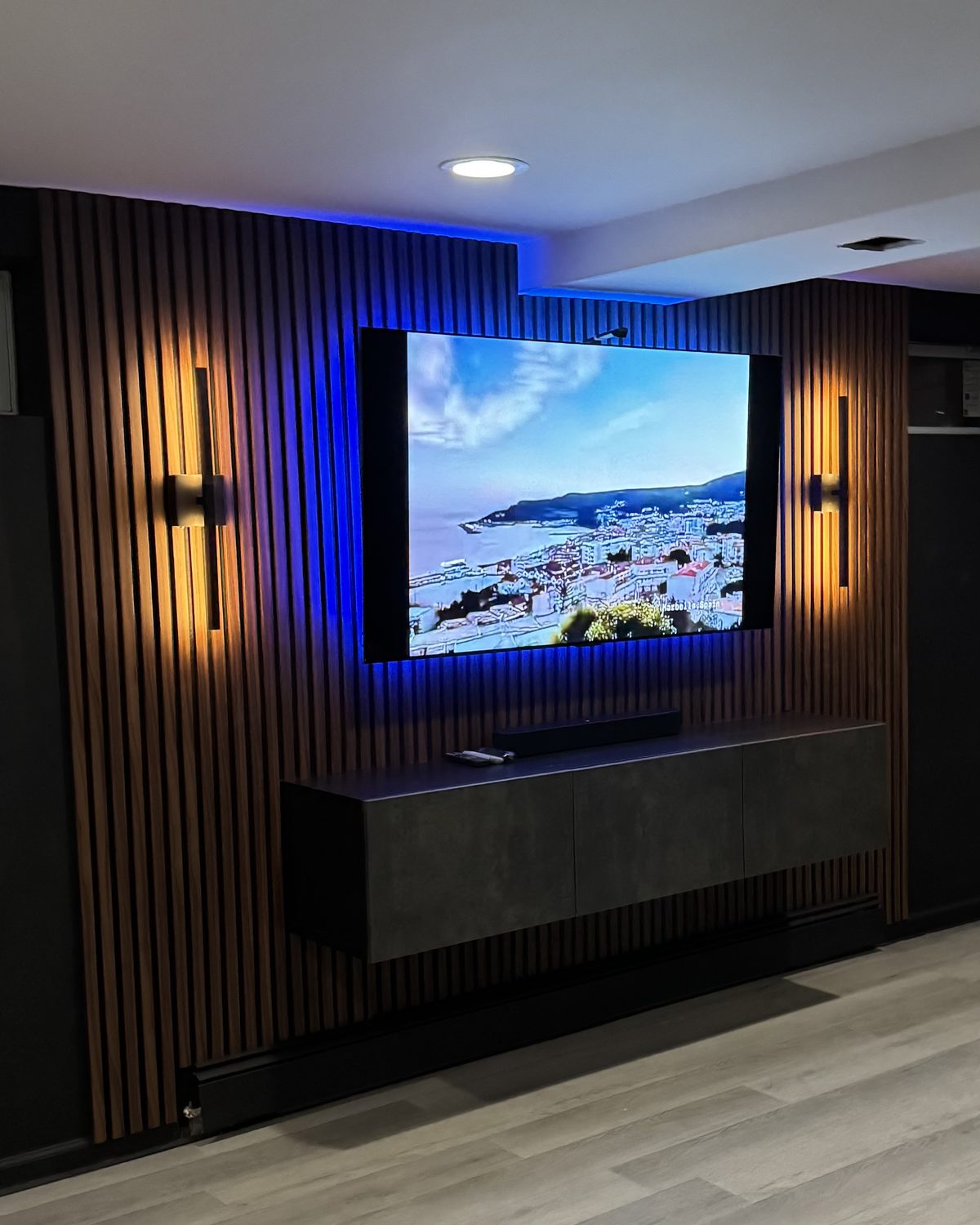 The Lounge: warm wood slat wall with recessed TV look and LED backlighting, a renter-friendly SEIN design