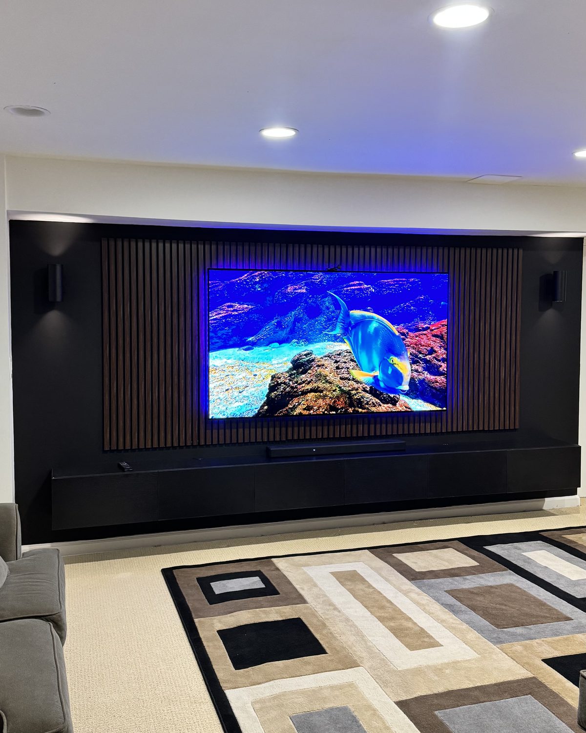 The Theatre, dual black slat columns flanking a wall TV by SEIN ME